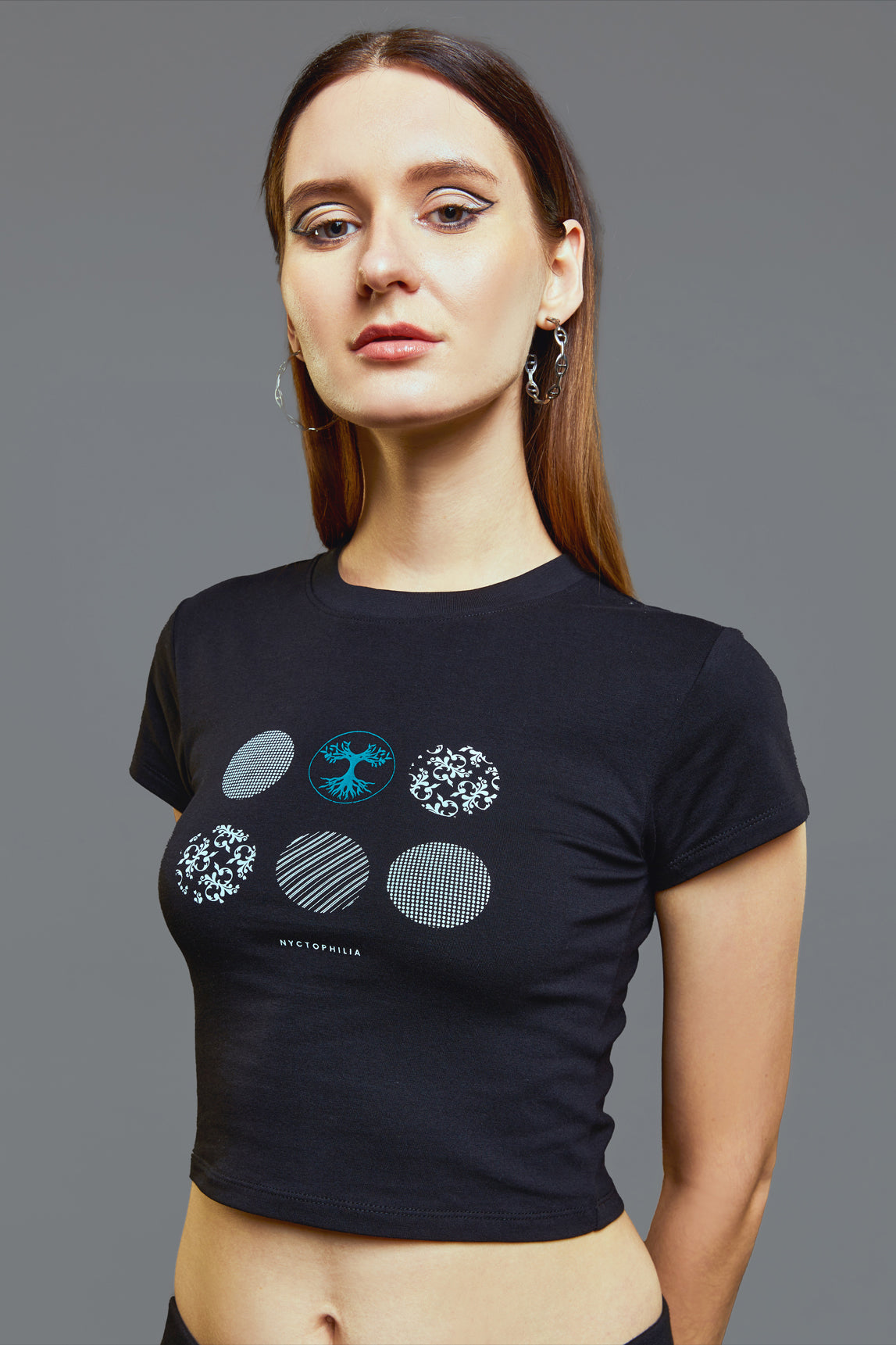 a woman standing in front of a wall holding a tennis racket