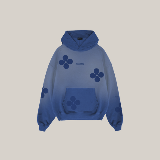 Front view of a blue gradient hoodie featuring darker blue floral motifs across the chest, sleeves, and pocket, with a kangaroo pocket, ribbed cuffs and hem, and subtle “Forbidden” text near the chest, shown against a neutral background.