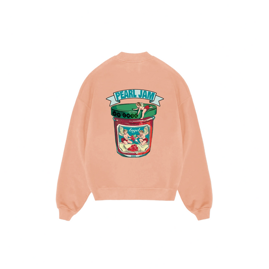 Peach-colored sweatshirt featuring a vintage-style banner reading "Pearl Jam" with a pin-up girl illustration. The style is retro and playful.