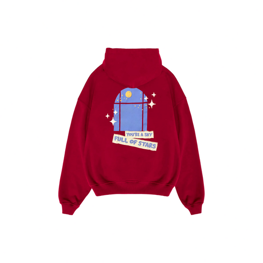 Bright red hoodie with a front graphic featuring the text “I’M GONNA GIVE YOU MY HEART” in playful, cut-out style lettering. Small colorful heart shapes are scattered around the text. The hoodie has a front kangaroo pocket and relaxed fit.