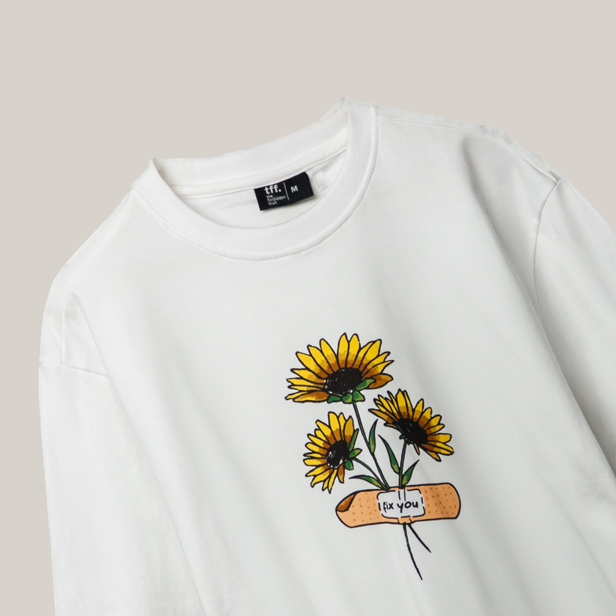 A white t-shirt showcasing a colorful sunflower print, a delightful choice for a fresh and lively look.