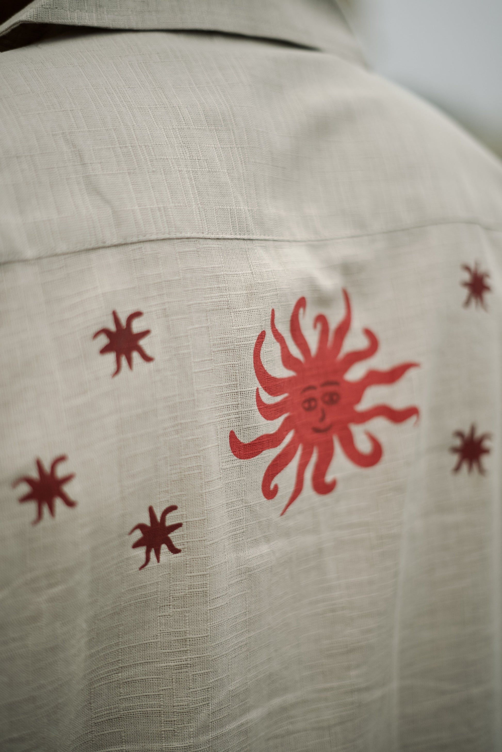 Short-sleeve beige button-up shirt, featuring decorative on the sleeves and two stylized tree graphics with star along with the word “Forbidden” embroidered on the chest.