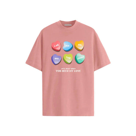 Pink T-shirt featuring colorful candy hearts with text: "call me on my cell phone" and "Late night when you need my love," on a beige background.